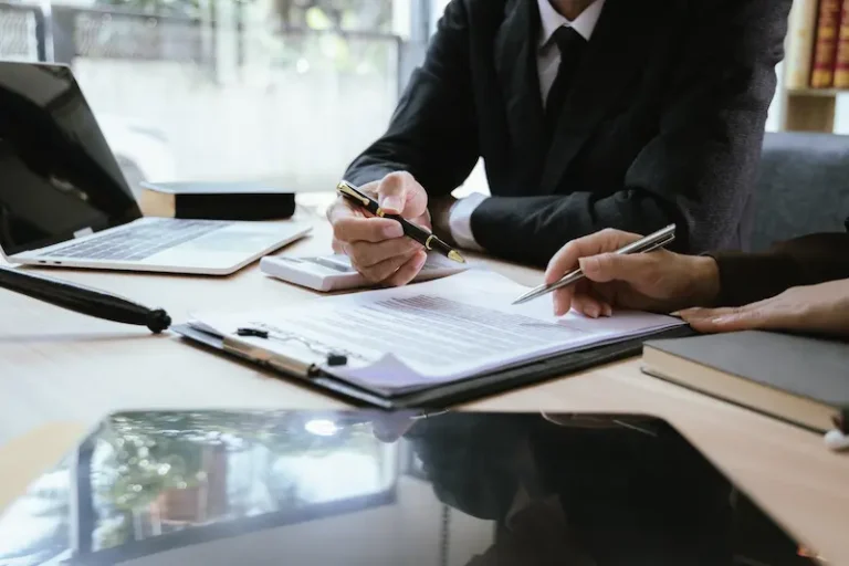 A lawyer goes through documents with a client at his desk regarding a personal injury settlement in Alpharetta.