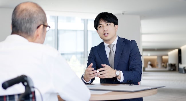An elder law attorney is discussing resident rights and legal protections with an elderly nursing home patient during a consultation meeting.